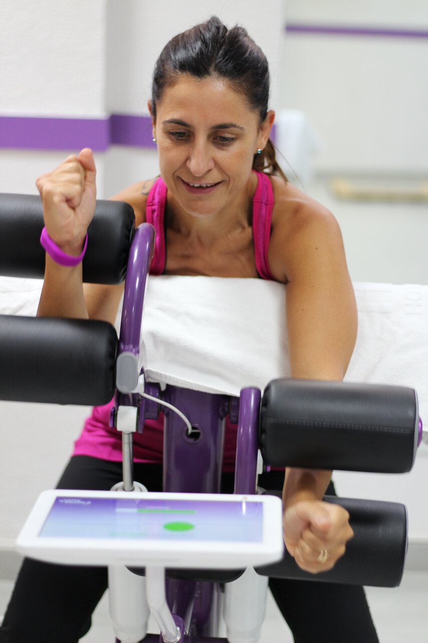 donna in palestra su macchina riabilitativa fitness