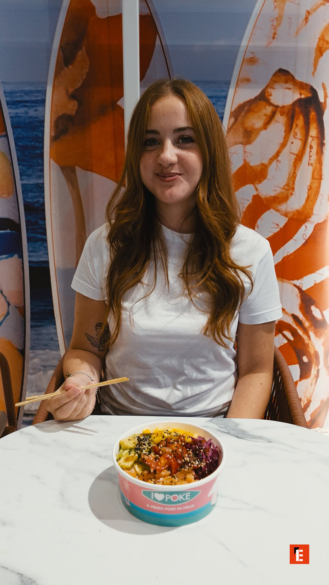 ragazza sorridente con poke bowl al ristorante