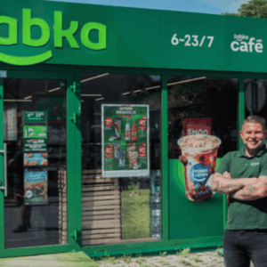 hombre tatuado en entrada de Żabka verde