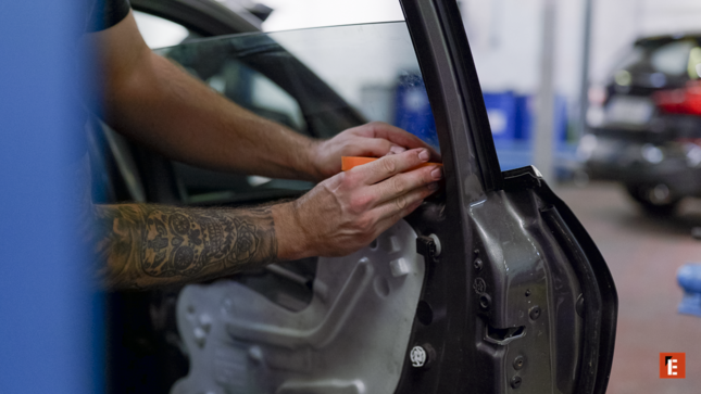 main tatouée posant une garniture de porte auto