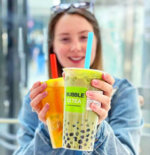 woman holding two bubble tea drinks