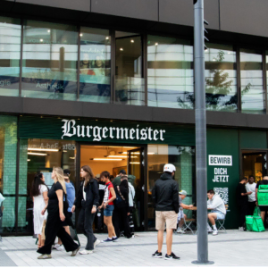 burgermeister berlin: lebendige straßenszene vor dem restaurant