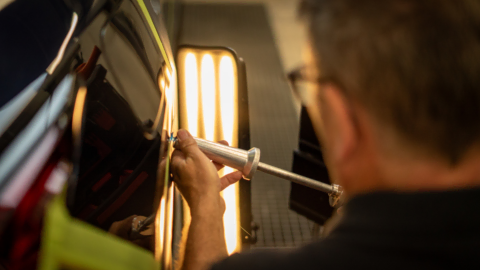 réparation de carrosserie avec outil de débosselage