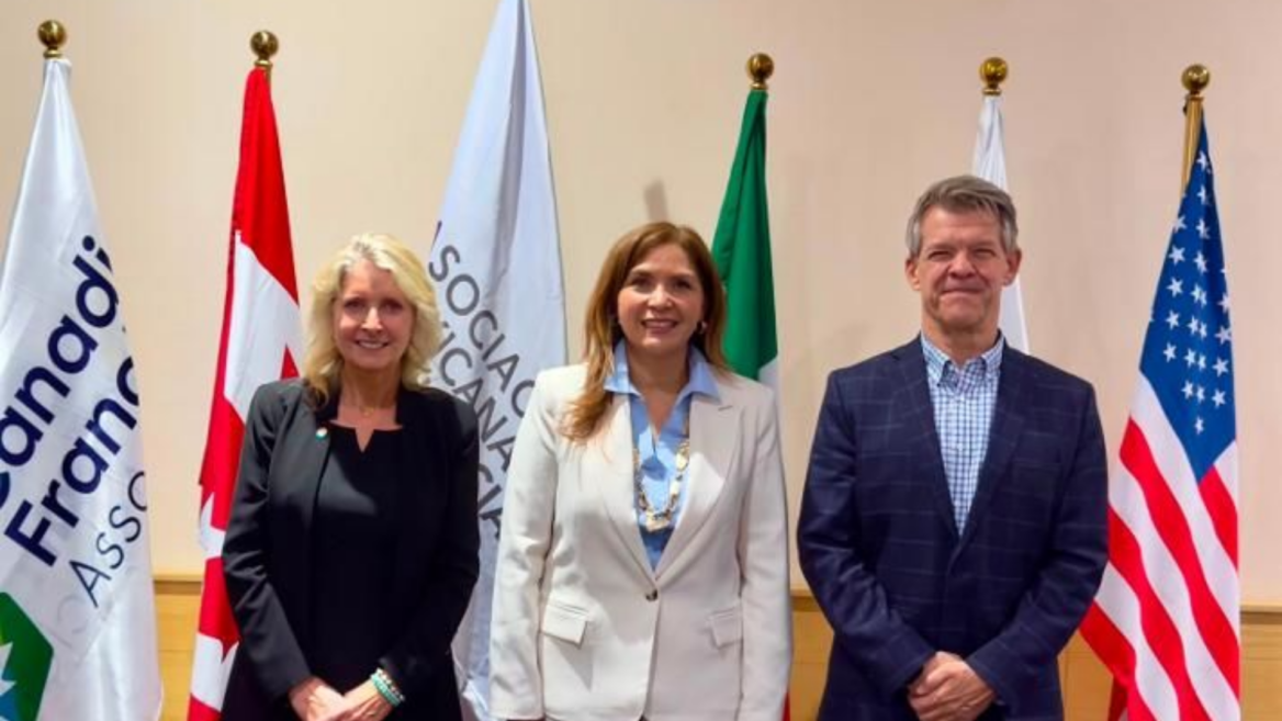 three officials posing before international flags