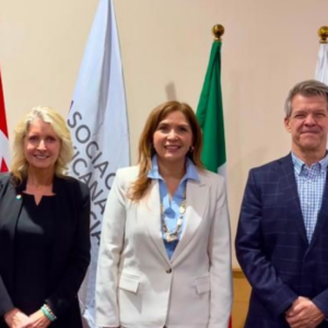 three officials posing before international flags