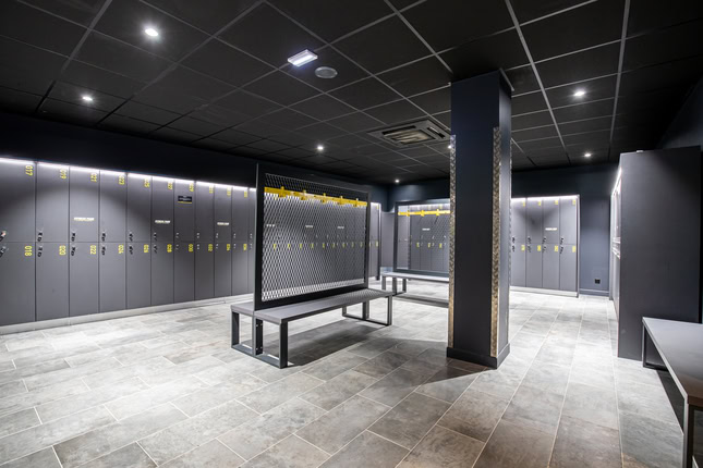 vestiaire moderne vide avec casiers gris et banc central