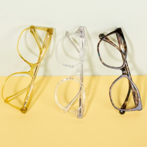 trois paires de lunettes design sur fond pastel