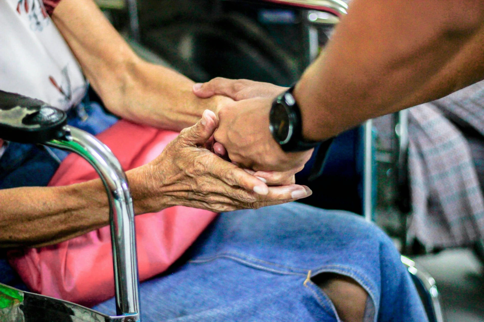 mano solidale tra anziano e caregiver