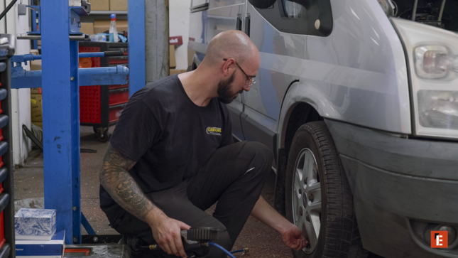mécanicien inspectant la roue d’un van en atelier