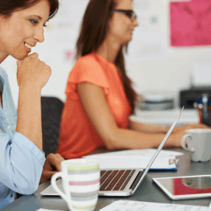 mujeres en oficina colaborando con ordenador