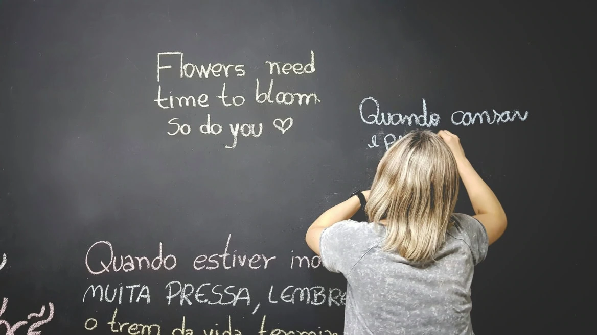 donna scrive frasi ispirazionali su lavagna nera