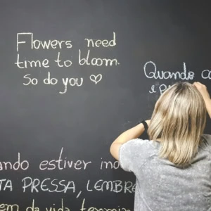 donna scrive frasi ispirazionali su lavagna nera