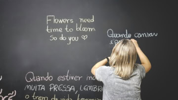 donna scrive frasi ispirazionali su lavagna nera