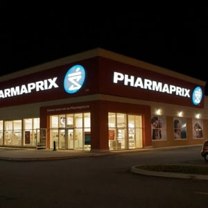 pharmaprix illuminé de nuit, façade et parking vide