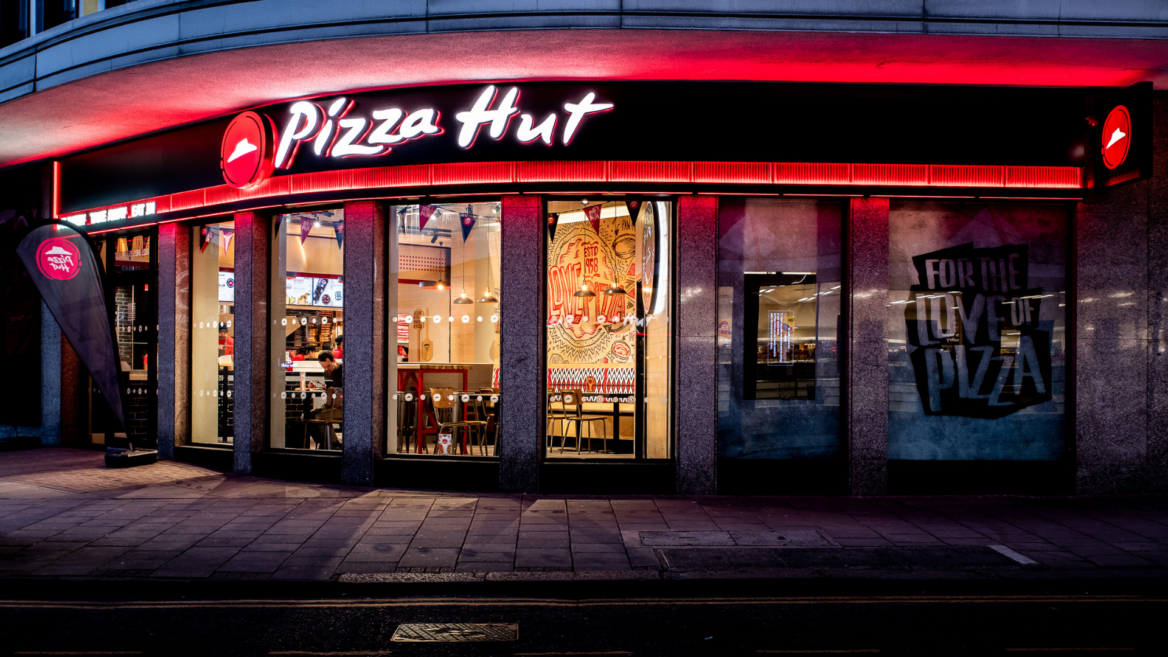 pizza hut storefront at night with neon sign