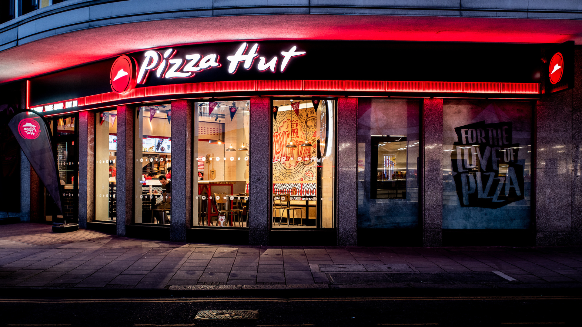 pizza hut storefront at night with neon sign