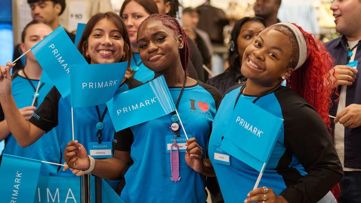 staff primark sorridenti con bandierine blu