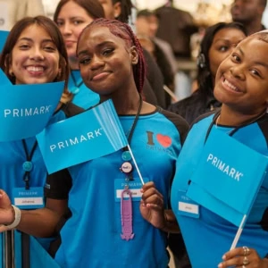 staff primark sorridenti con bandierine blu