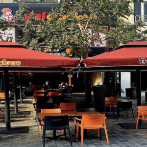terrasse belchicken avec parasols rouges et tables dehors