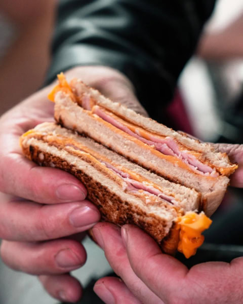 sandwich grillé jambon fromage, tenu À la main