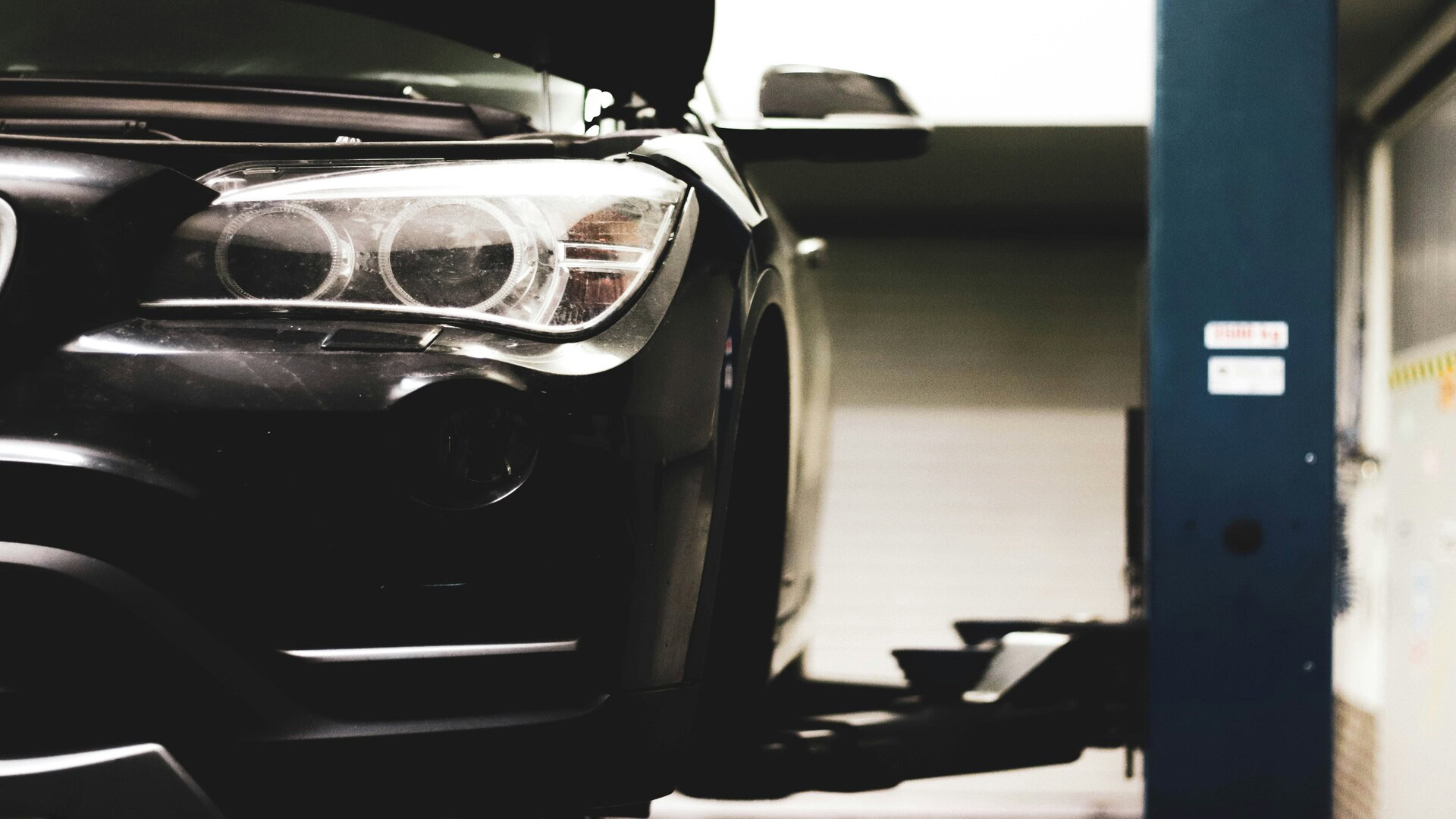 suv noir en atelier, phare avant ouvert