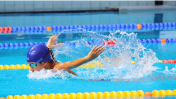 swimmer mid stroke in blue pool splash