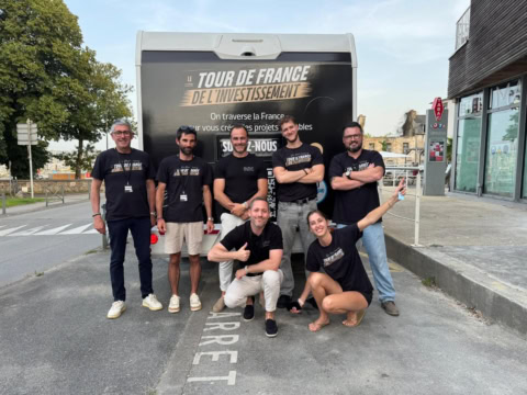 Équipe tour de france de l’investissement devant le van