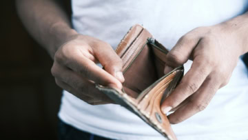 homme tenant portefeuille vide en cuir usé
