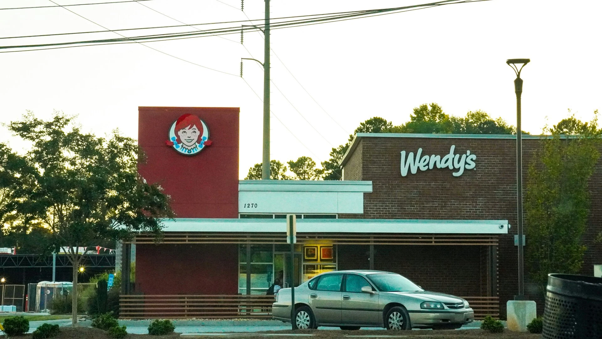 wendy’s al tramonto con auto parcheggiata