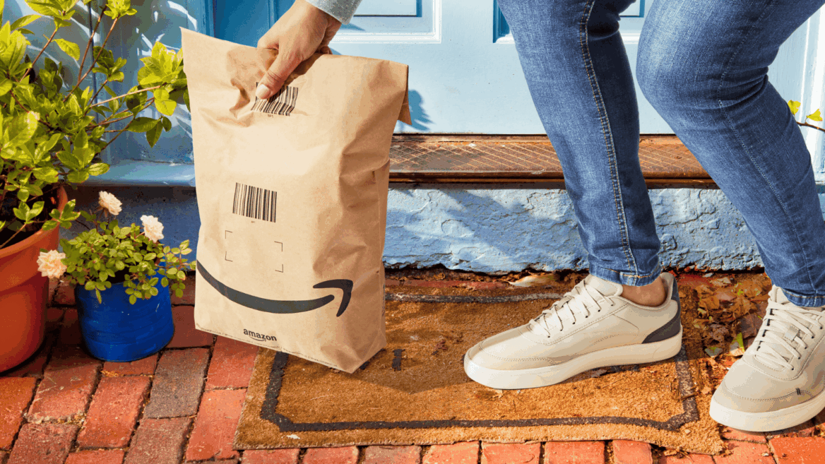 entrega amazon en puerta azul con paquete marrón