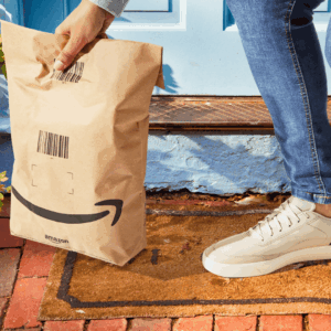entrega amazon en puerta azul con paquete marrón