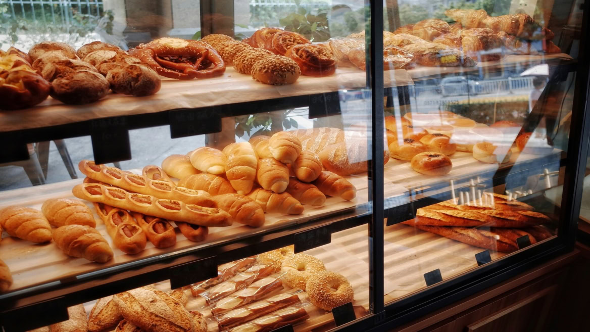 bakery display case with fresh breads and pastries
