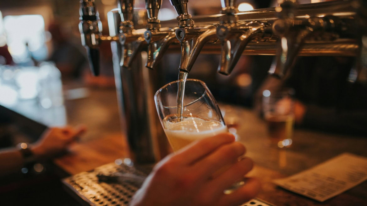 beer tap pouring golden lager in a bar