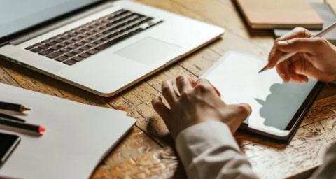 tablette et ordinateur portable sur bureau en bois