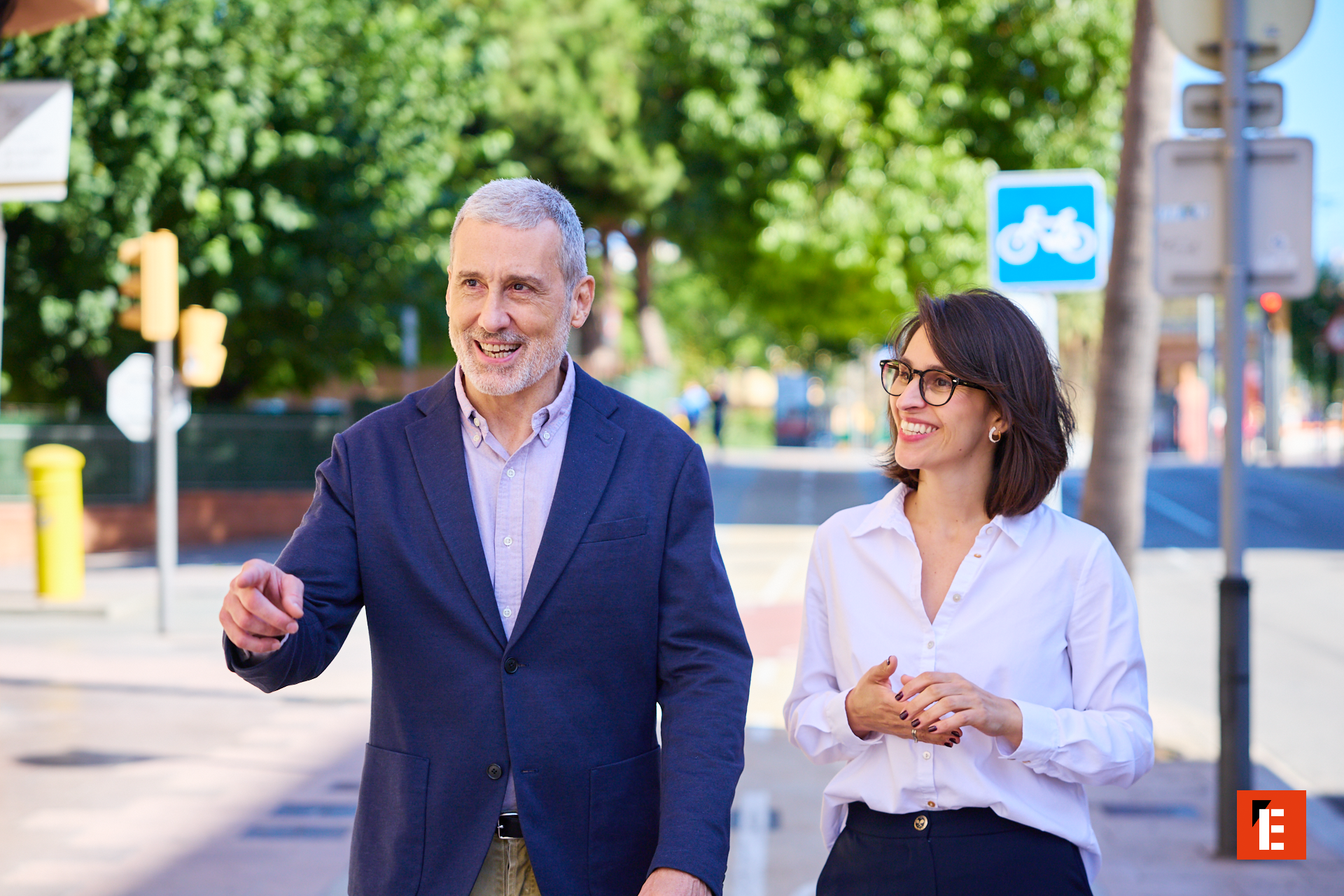 pareja sonriente caminando y conversando en la ciudad