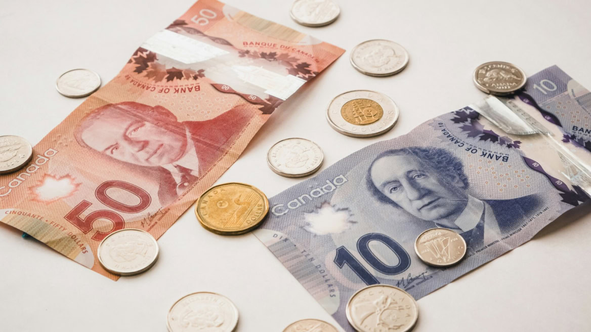 billets et pièces canadiennes sur fond clair