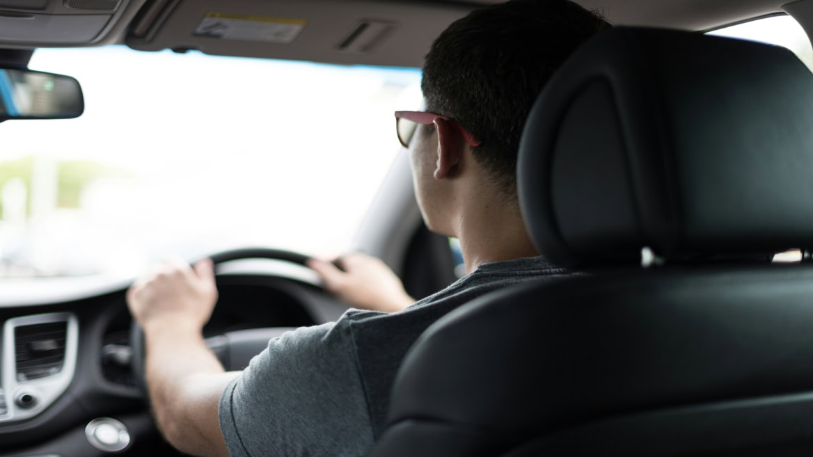 back seat view of driver at the wheel