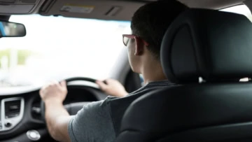 back seat view of driver at the wheel