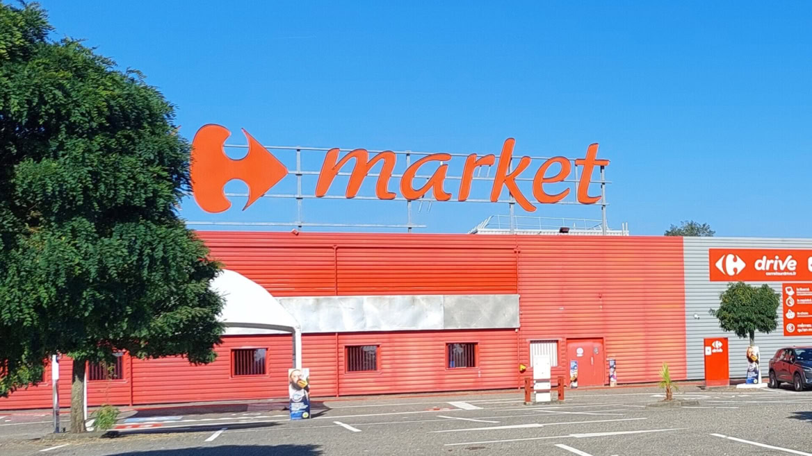 façade carrefour market sous ciel bleu