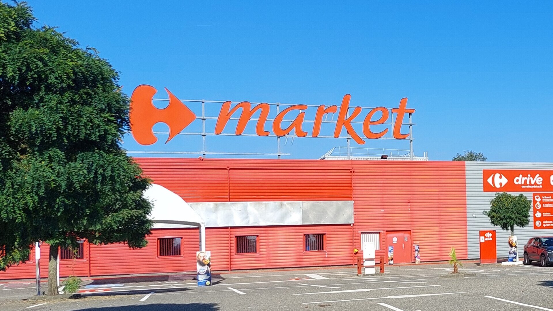 façade carrefour market sous ciel bleu