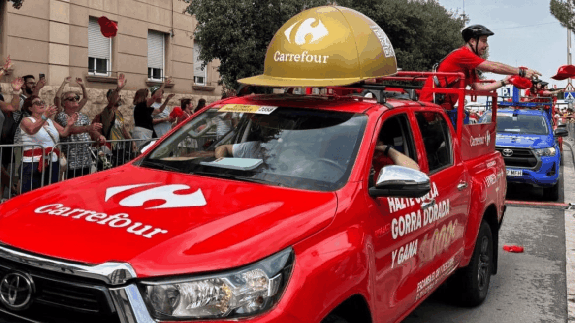 desfile promocional carrefour con camión rojo y casco dorado