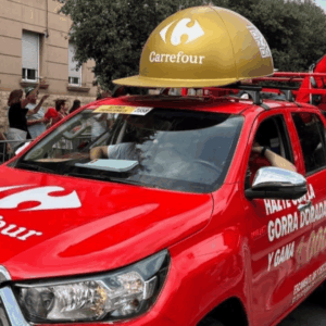 desfile promocional carrefour con camión rojo y casco dorado