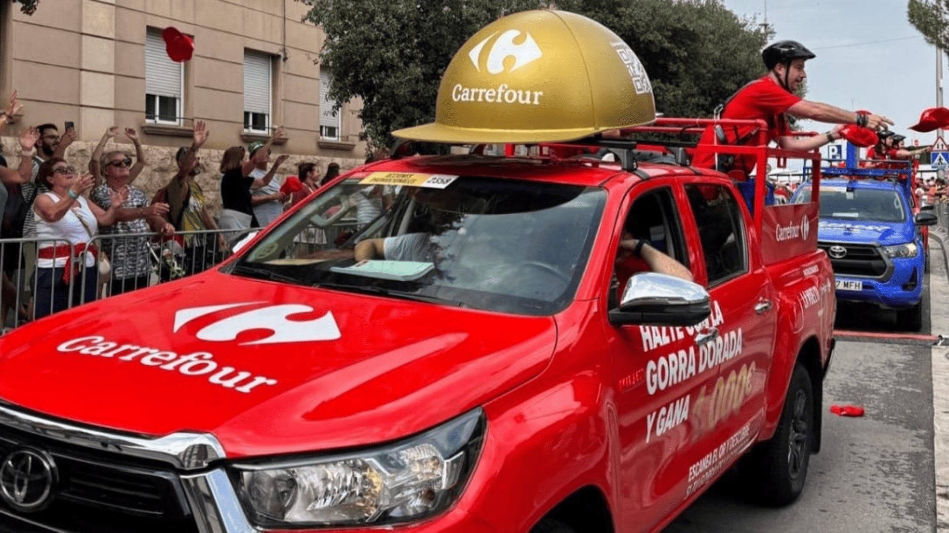 desfile promocional carrefour con camión rojo y casco dorado