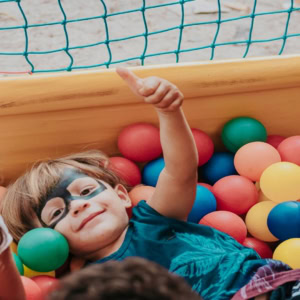 child smiling in colourful ball pit