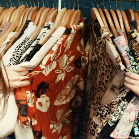 colorful patterned clothes on a crowded rack