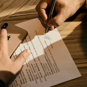 signature de contrat avec smartphone doré et main écrivant