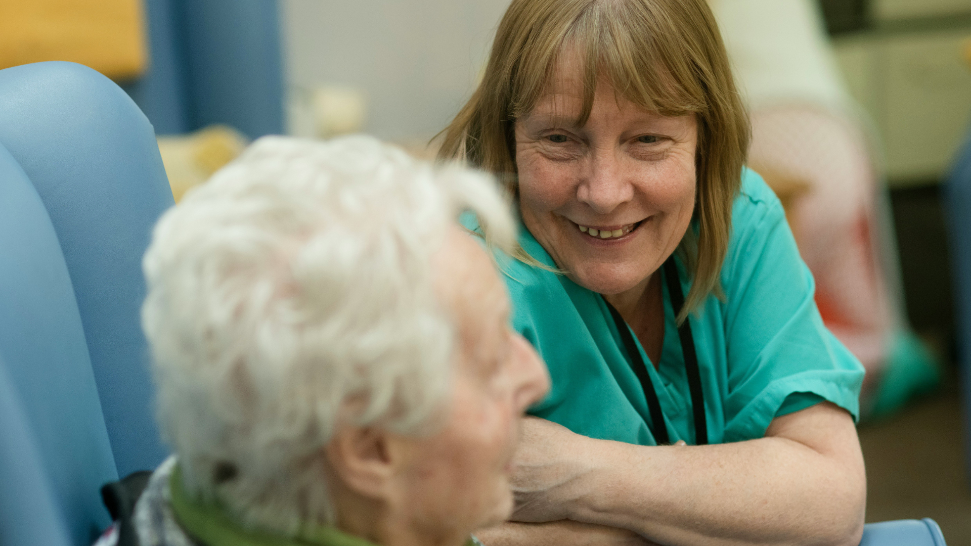 warm caregiver smiles with elderly woman