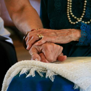 elderly hands holding a companion’s hand