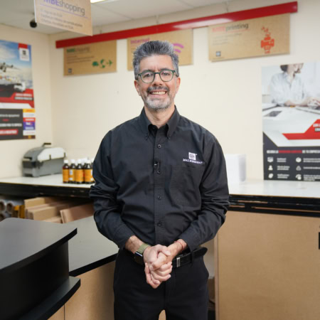 empleado sonriente en mostrador de envíos y copias