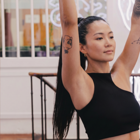 jeune femme brune en posture de yoga, bras levés